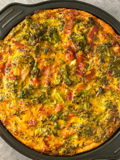 roasted broccoli, bacon, and cheddar quiche in a round baking dish