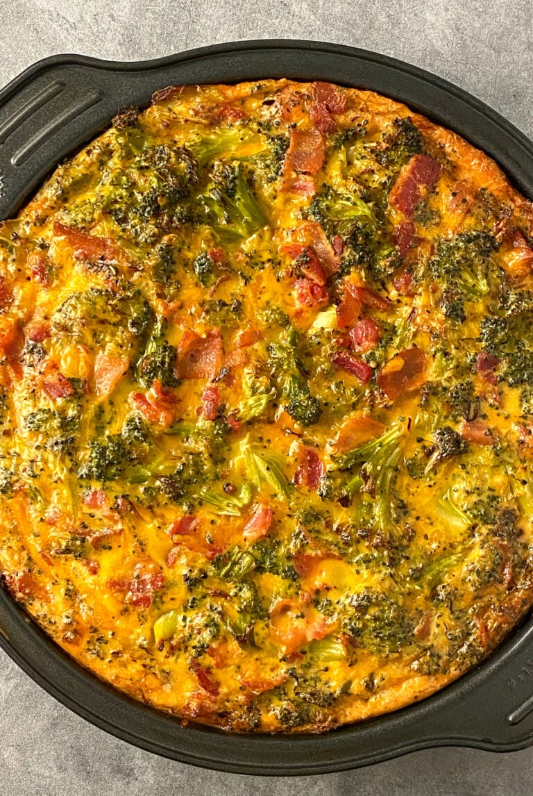 Roasted broccoli, bacon and cheddar quiche in a round baking dish