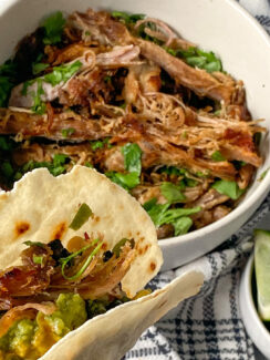 an almond flour tortilla filled with shredded crockpot carnitas meat served with lime wedges