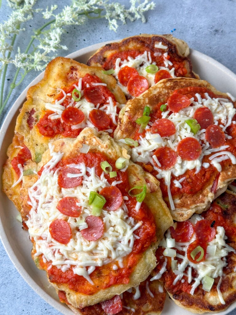 pizza pancakes with mini pepperonis and mozzarella cheese on a white serving dish