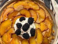 Peach upside down cake made with almond flour and topped with whipped cream and black berries
