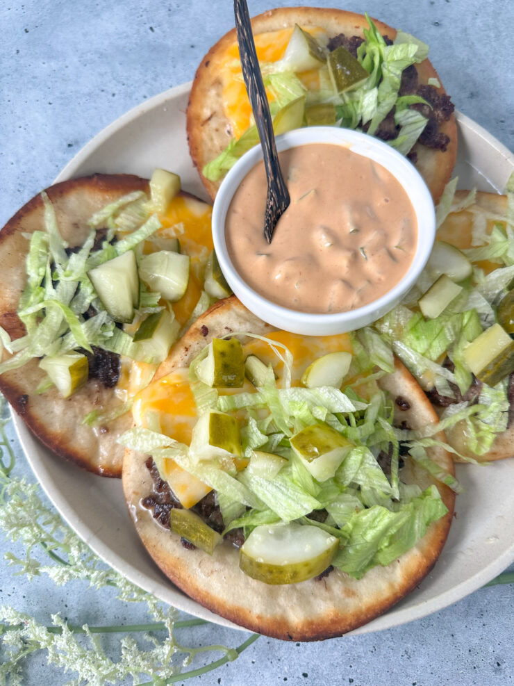 Big Mac smash burger tacos on a white plate with Big Mac sauce served with lettuce and pickles.