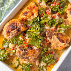 crockpot chicken thighs in a white baking dish with creamy coconut lemon sauce and kale