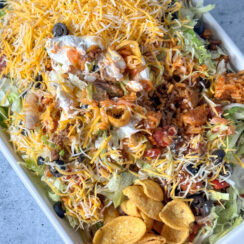 Fritos topped with ground beef, shredded cheese, lettuce, black olives, salsa, and sour cream