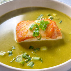 pan-seared sea bass in a coconut cilantro soup with diced green onions sprinkled on top