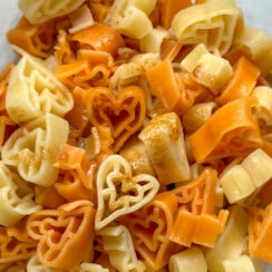 white and orange heart shaped pasta with brown butter sauce on top
