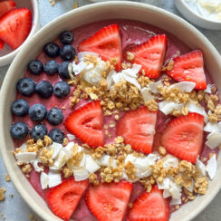 superfoods patriotic smoothie bowl topped with a design of the American flag created with blueberries, strawberries, bananas, coconut, and granola