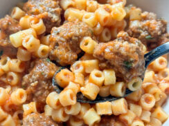 homemade spaghettiOs with mini meatballs in a gray bowl with black spoon