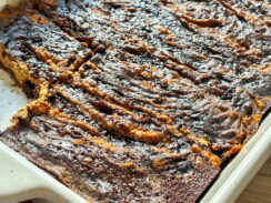 ricotta pumpkin pie brownies in a white baking dish with a slice missing