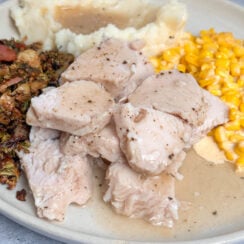 the easiest way to make thanksgiving turkey in the crockpot - juicy turkey breast tenderloin cooked to perfection and served with creamy corn, mashed potatoes, and crispy Brussel sprouts all smothered in turkey gravy