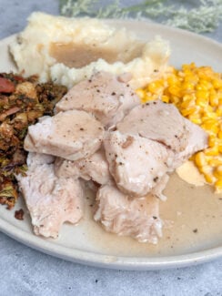 the easiest way to make thanksgiving turkey in the crockpot - juicy turkey breast tenderloin cooked to perfection and served with creamy corn, mashed potatoes, and crispy Brussel sprouts all smothered in turkey gravy