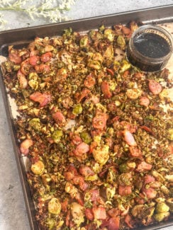 crispy bacon brussel sprouts perfect for the holidays on a sheet pan served with balsamic honey glaze