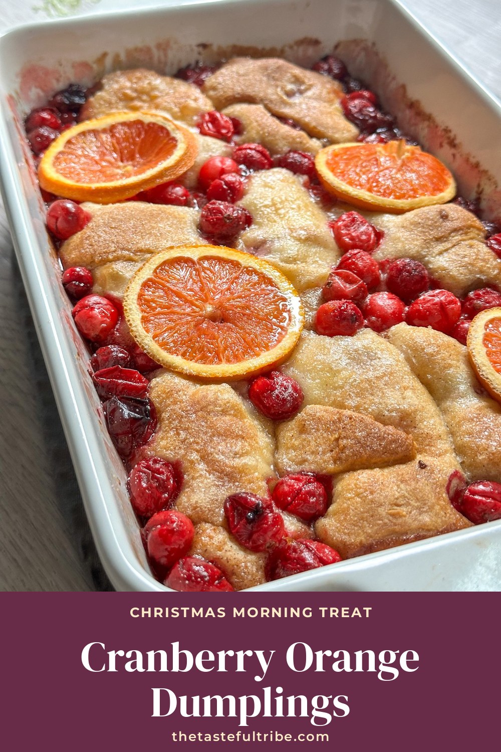 Baking dish of cranberry orange cream dumplings with fresh cranberries and orange slices