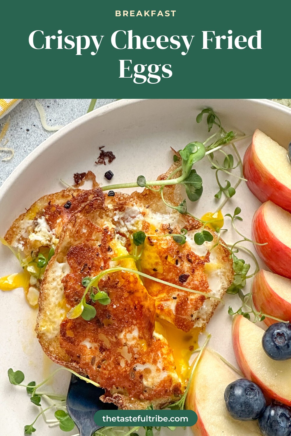 crispy cheese fried egg on a white plate with a slightly runny egg yolk and fresh sprouts served with apples and blueberries