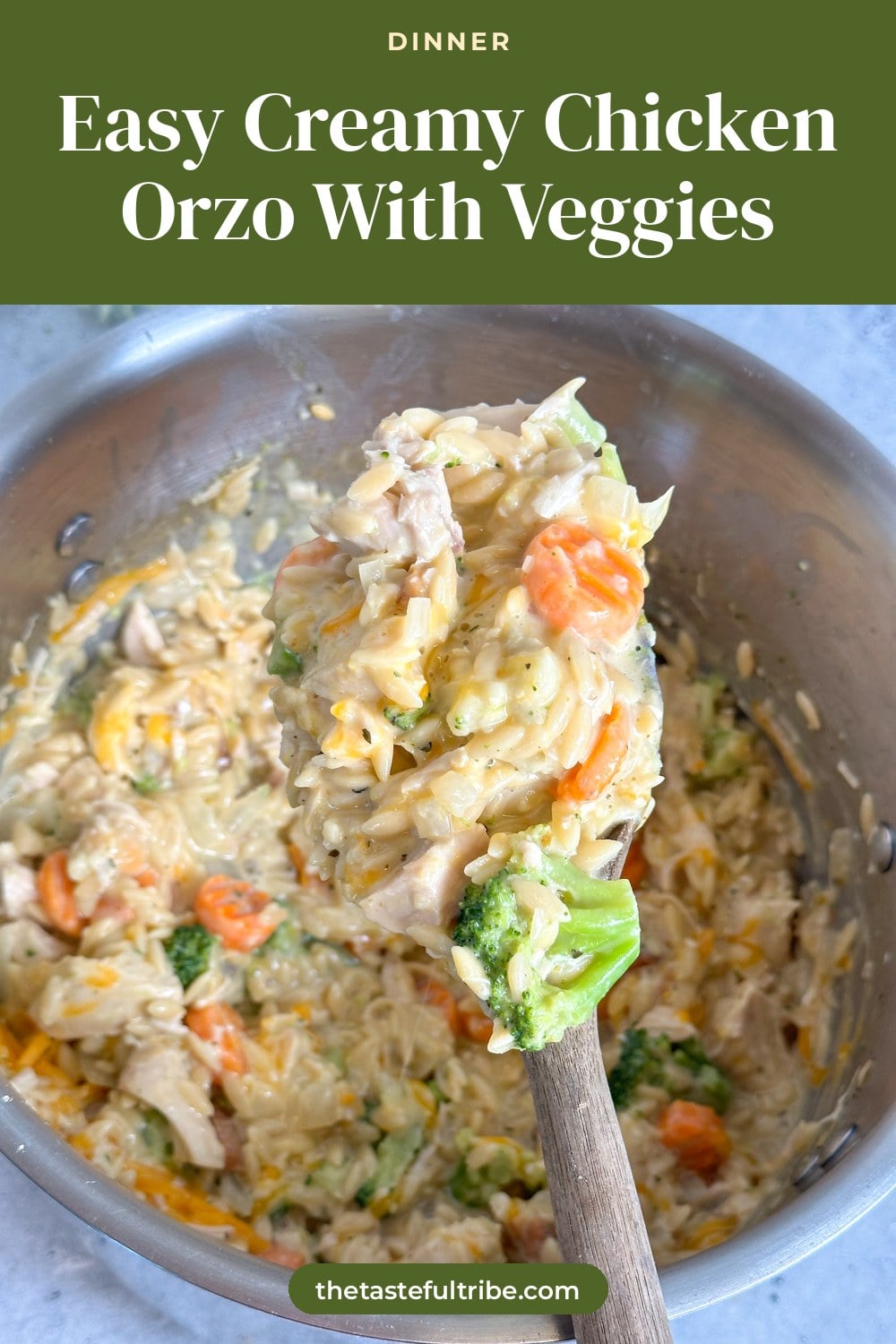 creamy orzo with chicken, broccoli, carrots, and cauliflower in a large pot with a wooden serving spoon