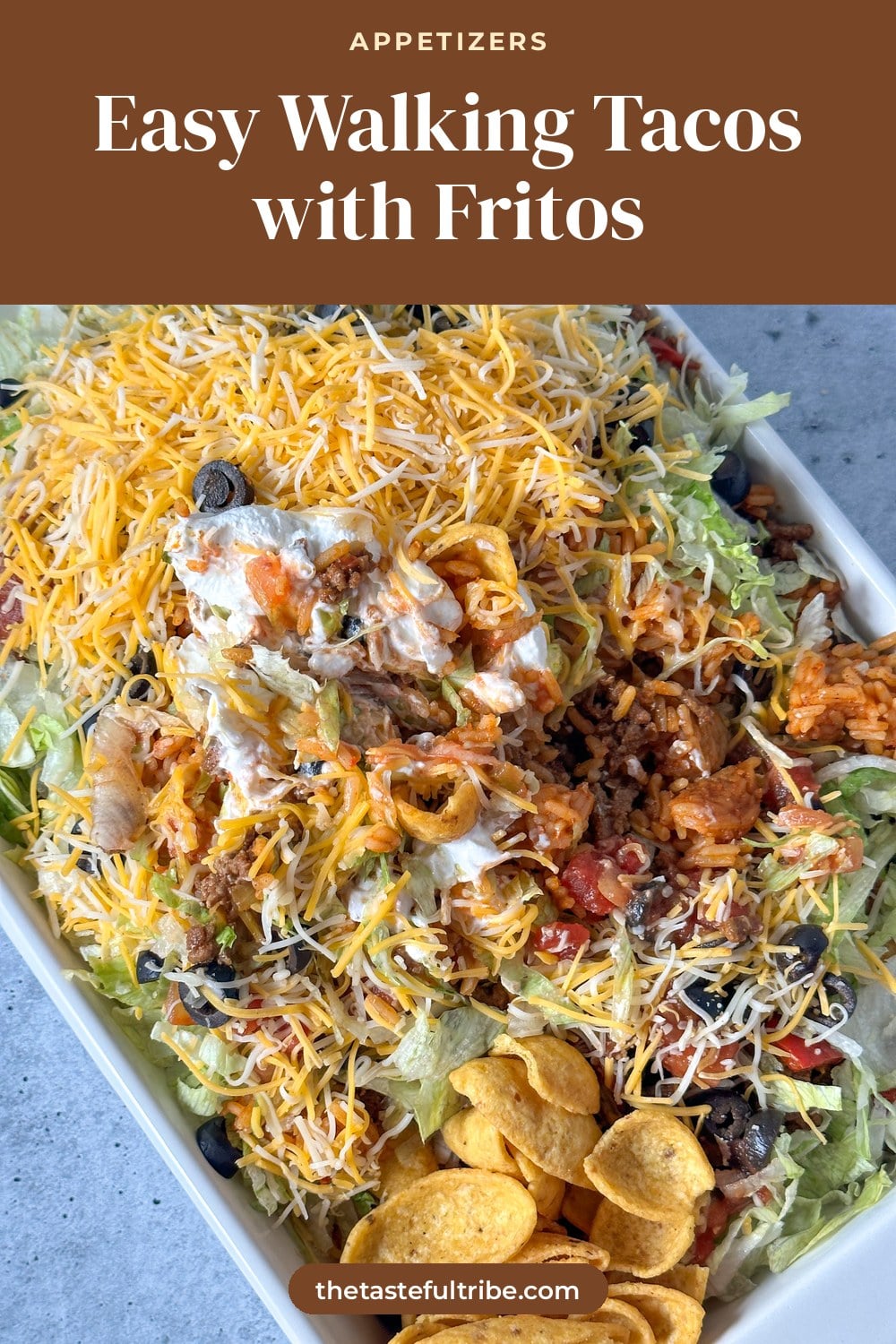 Fritos topped with ground beef, shredded cheese, lettuce, black olives, salsa, and sour cream