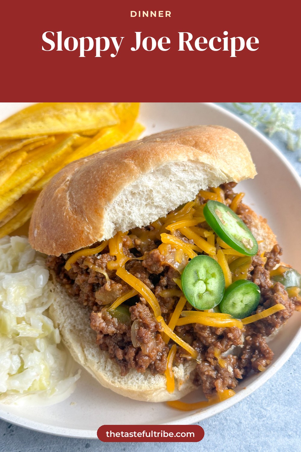 sloppy joes on a hamburger bun with cheddar cheese and sliced jalapeño peppers