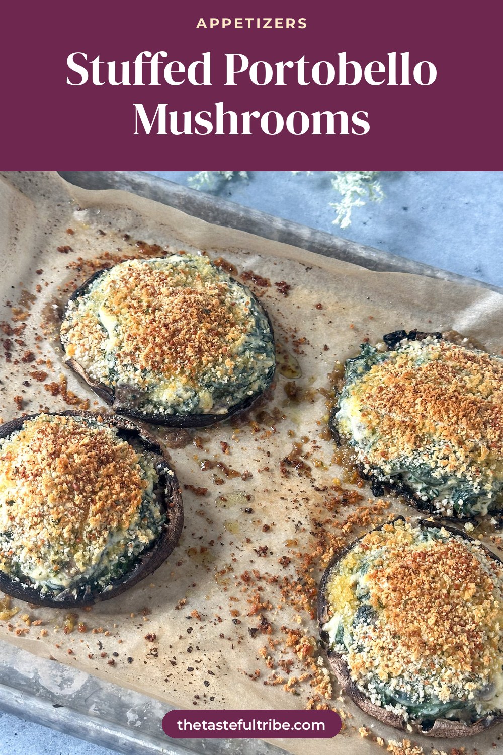 large portobello mushrooms on a baking sheet with parchment paper stuffed with spinach, boursin cheese and topped with crispy breadcrumbs.